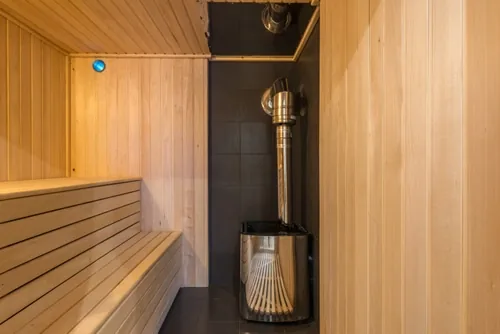 Pieni sauna, puukiuas ja tummalaatoitettu pesutila Turussa